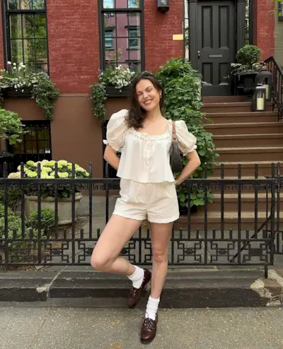 woman wearing white breezy shorts with matching eyelet top and loafers