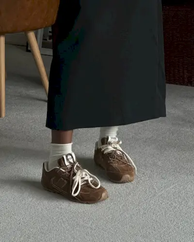 An image of @nlmarilyn wearing brown sneakers, one of the biggest trainer trends of 2025.