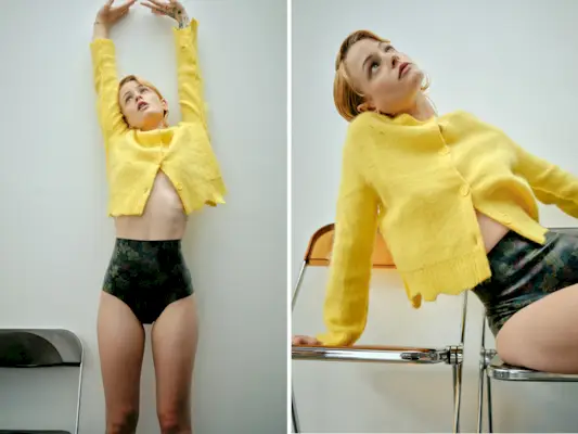 Esther McGregor wearing a bright yellow cardigan and dark green briefs.