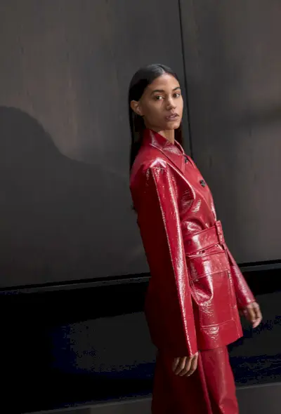 A woman wearing a blazer, vest and tailored trousers