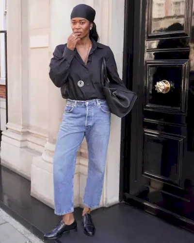 Stockholm Fashion Trends 2025: @nlmarilyn wears a black shirt, blue jeans and a long pendant necklace