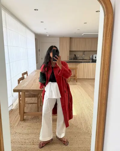 Stockholm Fashion Trends 2025: @monikh wears a red trench coat with white linen trousers
