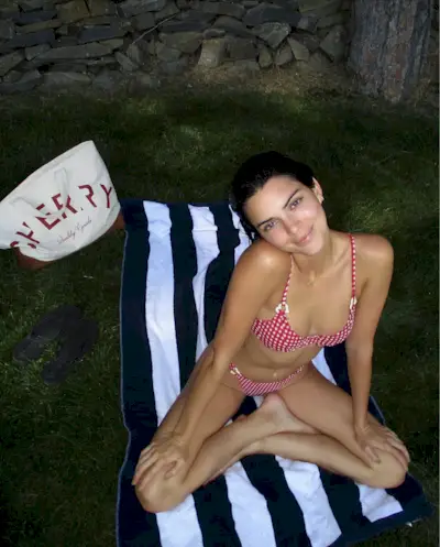 Model Chey in a tropical print bikini with a green headband and chunky bangals