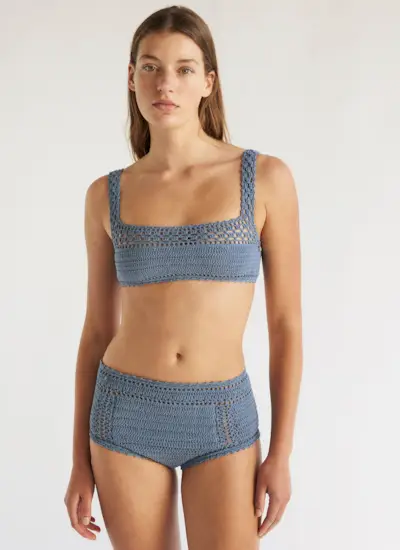 a model wears a blue crochet bikini top with matching bikini bottoms