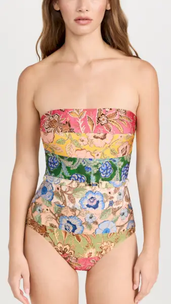 a model wears a strapless one-piece swimsuit with a patchwork floral design
