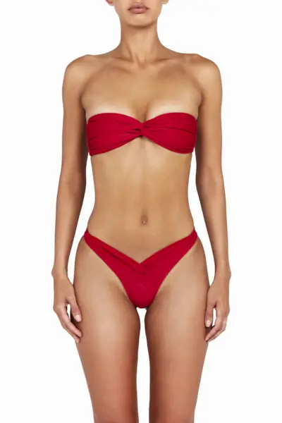 a model wears a red strapless bikini top with matching crossover bikini bottoms