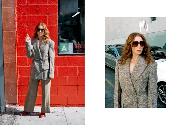 Actress Ari Graynor wears gray tweed pantsuit with red heels and oversize square sunglasses.