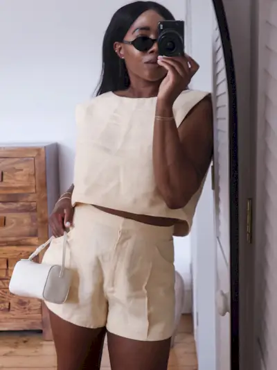 @_loissterling wears a butter yellow top and matching shorts with a white leather mini bag