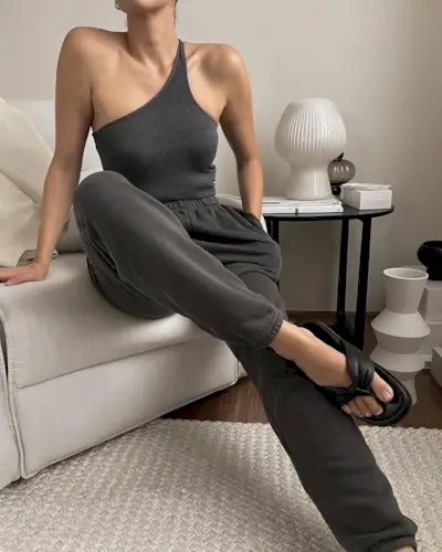 woman wearing one-shoulder grey tank and matching pants