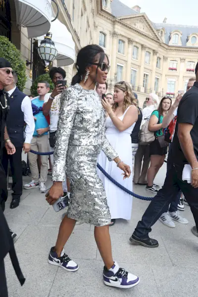 Naomi Campbell wearing a sequin skirt set and blue and white Nike Air Forces in Paris