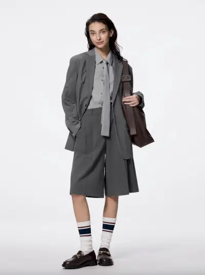 Coco wearing tweed jacket and matching Bermuda shorts with knee-high boots in Paris.