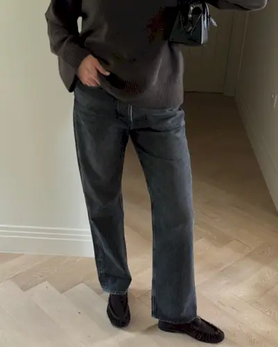 Fashion person Sarah Blyth wears a brown shoe outfit. She pairs her brown suede loafers with a dark washed jean and brown jumper in a recent image taken from her Instagram.