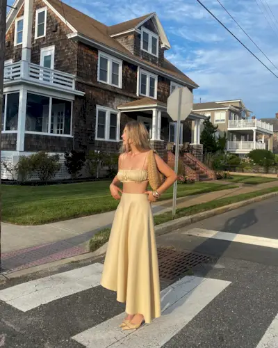 Influencer wears a yellow skirt.