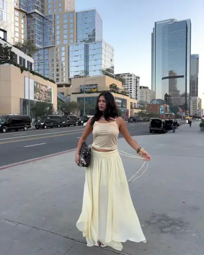 Influencer wears a yellow skirt.