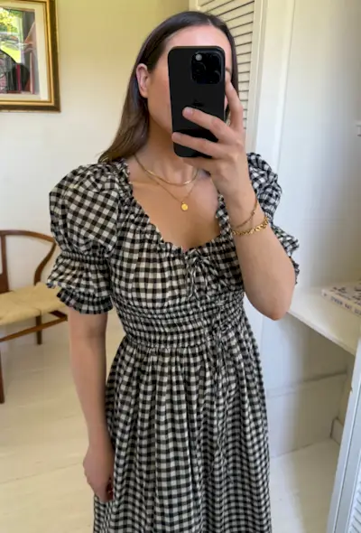 Woman wears gingham dress in mirror