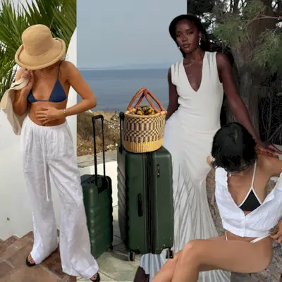 A woman in white linen trousers with a blue triangle top bikini and a bucket hat. Green luggage with a large woven tote on top. A woman sitting down wearing a black and white bikini. A woman in the background is wearing a white maxi dress. 