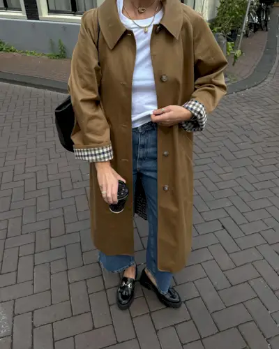 Woman wears trench coat and jeans