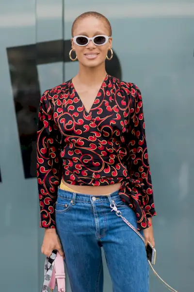 Woman wearing a printed top with jeans.