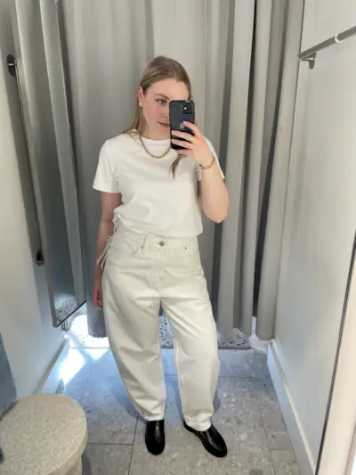 Woman wears white tee and white barrel leg jeans