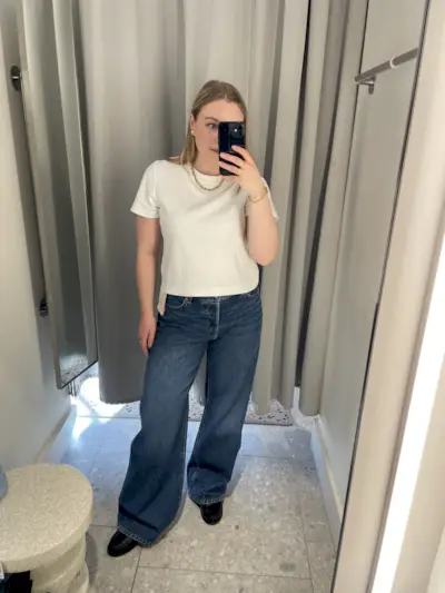 Woman wears white tee and blue wide leg jeans