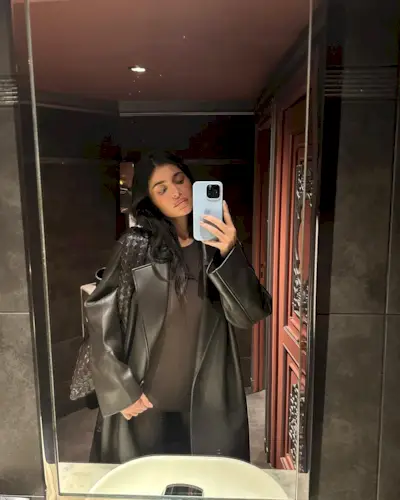 Kylie Jenner wears Bottega Veneta's The Hop bag in brown with a brown leather jacket, and brown catsuit.