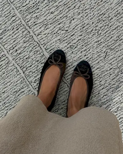 Woman wearing brown Chanel ballet flats.