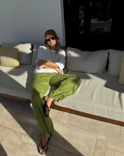 Lucy Williams wearing a white T-shirt and green linen pants.