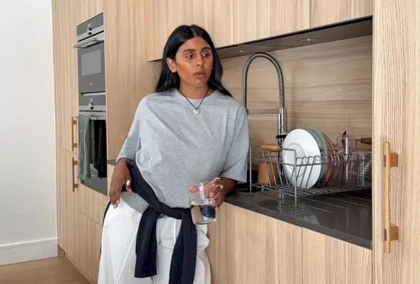 Monikh Dale wearing a gray T-shirt and white drawstring pants.