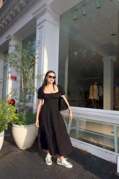 Renata D'Agrella wearing a black dress and silver sneakers.