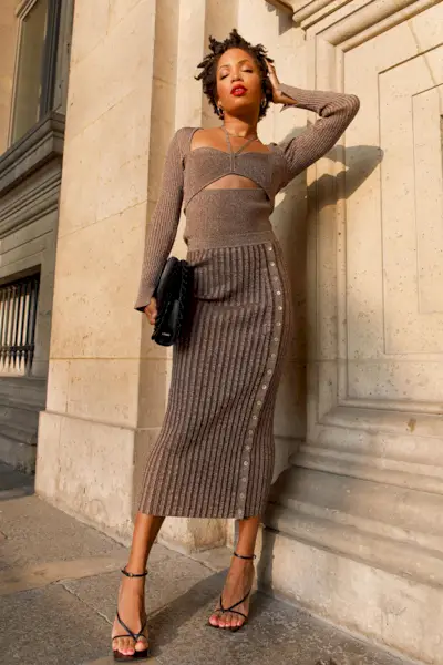 a photo of a sweater dress outfit with a woman wearing a brown cutout dress with black strappy sandals and a black clutch bag