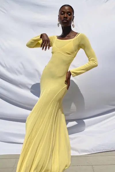 a photo of a sweater dress outfit with a woman wearing yellow bustier dress and long earrings