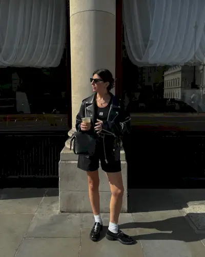 @francescasaffari wearing black denim shorts with a leather jacket and loafers