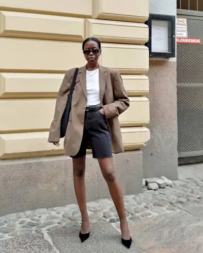 @sylviemus_ wearing black denim shorts, a blazer and heels
