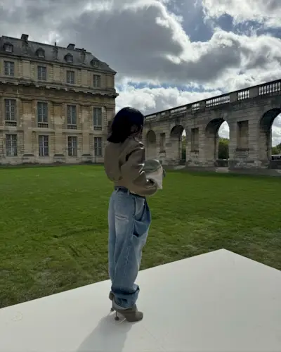 Woman wearing boots tucked into jeans trend fall 2025.