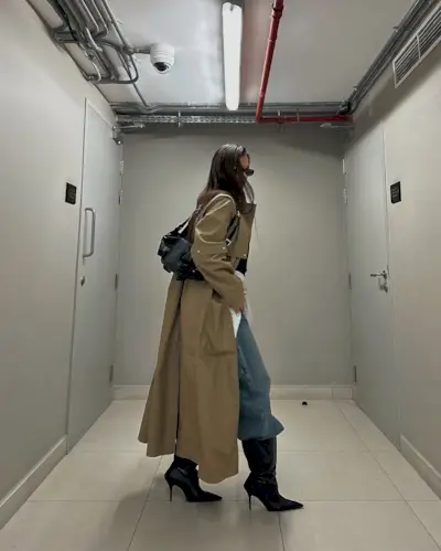 Woman wearing boots tucked into jeans trend fall 2025.