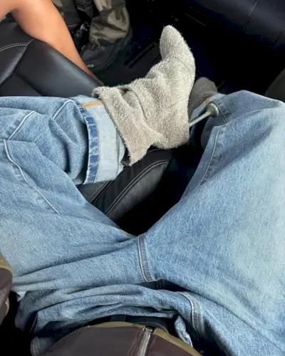 Woman wearing boots tucked into jeans trend fall 2025.