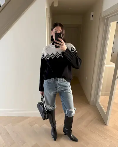 Woman wearing boots tucked into jeans trend fall 2025.