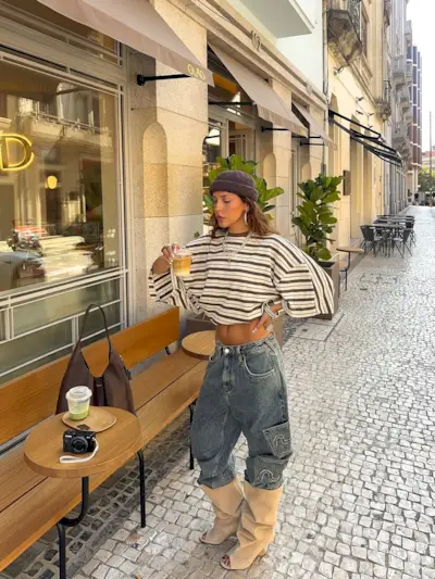 Woman wearing boots tucked into jeans trend fall 2025.