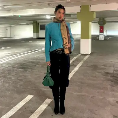 Woman wearing boots tucked into jeans trend fall 2025.