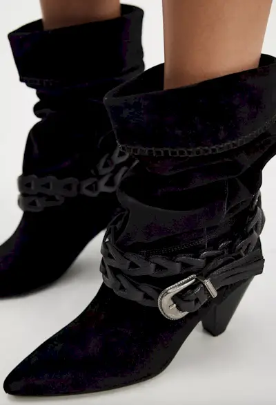 Woman wearing jeans tucked into boots trend fall 2025.