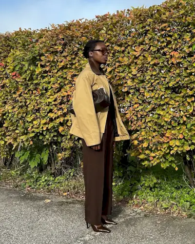 @chrystelleeriksberger wears a barn jacket with brown tailored trousers and heels