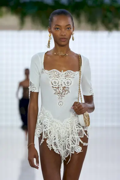 A woman wears tassel accented earrings on the chloe s/s 25 runway.