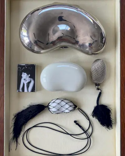 A tray of objects including a tassel necklace and tassel adorned object.