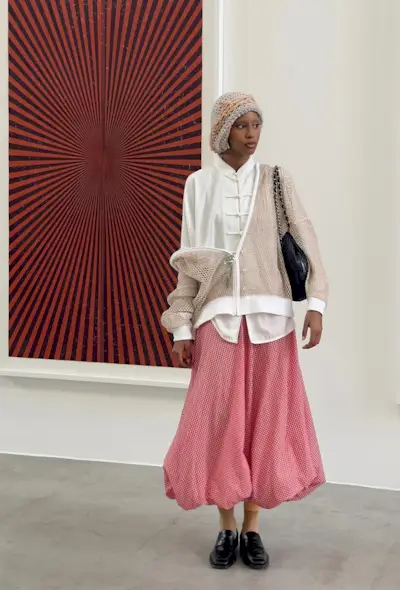 an influencer wearing a gingham print ballon skirt with a white shirt and tan cardigan