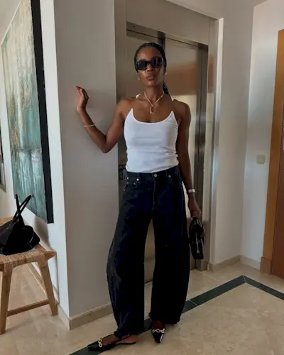 Marilyn wearing a white tank top and black jeans