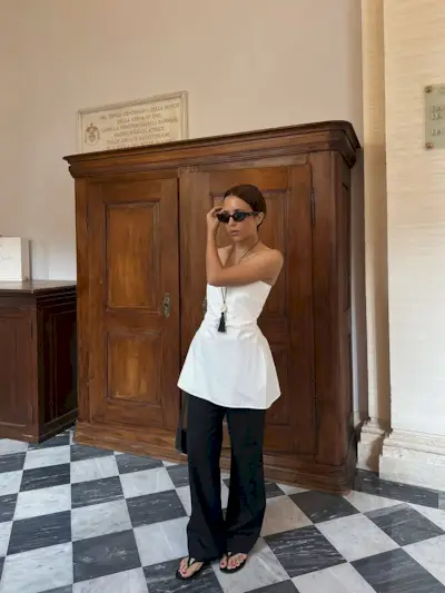 woman wearing strapless flared top and black pants summer 2025