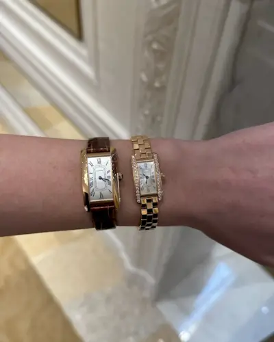 A close up shot of Kristen Nichols' wrist wearing two Cartier Tank watches.