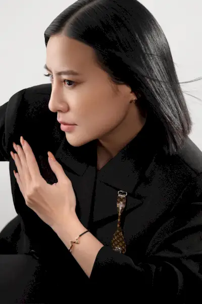 Savina Chow wearing a blazer blazer and a gold bracelet.