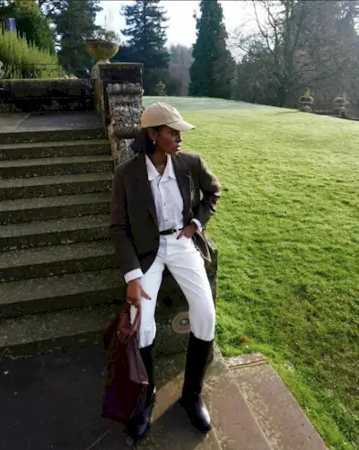 Sara wears a white button-down shirt, ralph lauren belt, and blue jeans.