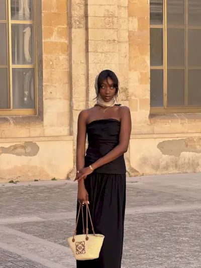 Woman holding a designer beach bag from Loewe.